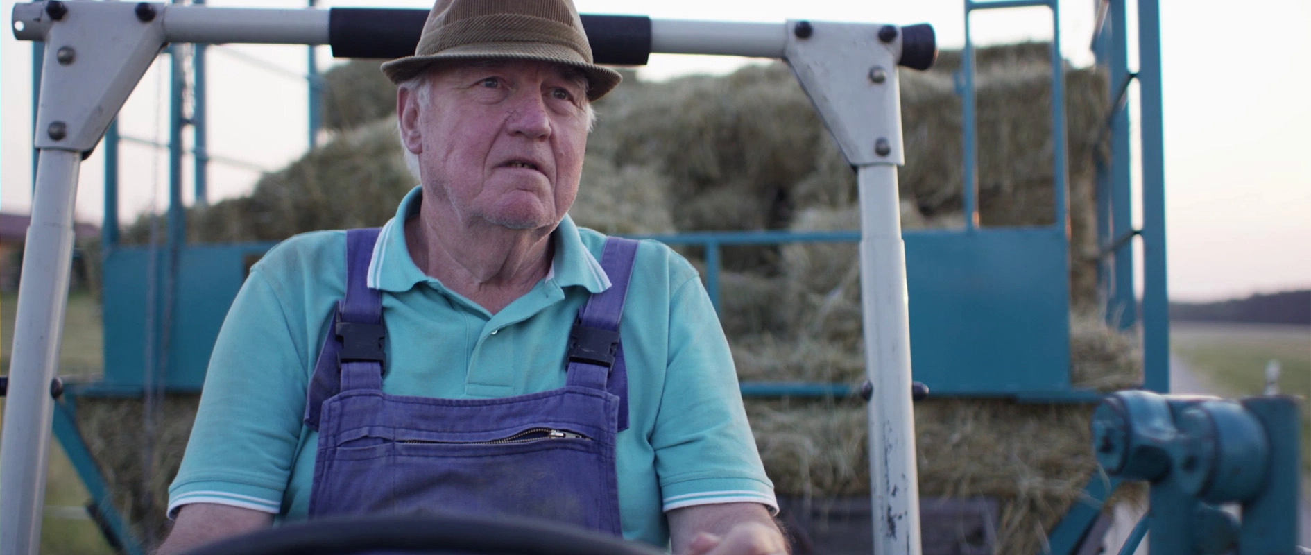 Filmproduktion Panda Pictures aus München und Ulm zum Thema DaVinci Resolve – Color Grading. Eine ungegradete Aufnahme eines Landwirts auf seinem Traktor. Die Lichtstimmung der Dreharbeiten wird erst in der Postproduktion finalisiert.