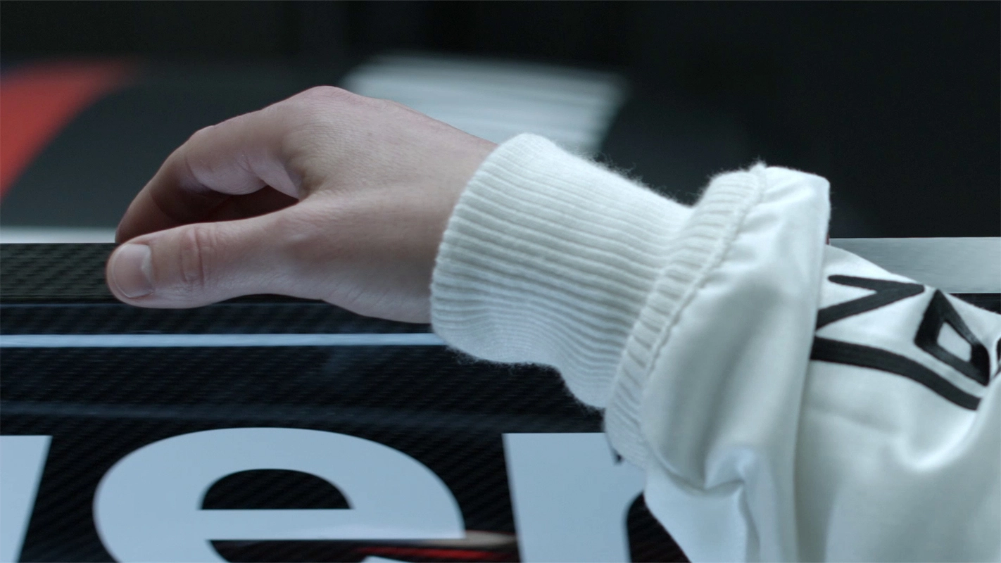 Filmproduktion Panda Pictures aus München und Ulm zum Thema Financial Services Imagefilm. Die Hand des Fahrers auf der Carbon-Karosserie. Die Kreation sinnlicher Bilder von Hightech-Materialien vermittelt ein Gefühl von Qualität und Wert.