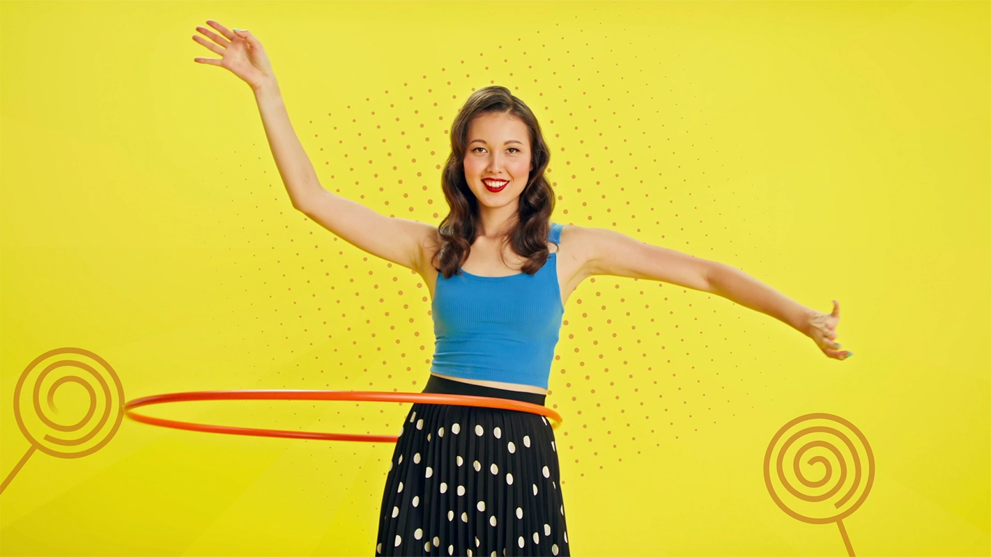 Filmproduktion Panda Pictures aus München und Ulm zum Thema JuZo – show your inner colors. Eine Frau mit Hula-Hoop vor einem gelben Hintergrund mit Pop-Art-Grafiken. Die Kreation dieses Werbespots setzt auf leuchtende Farben und positive Energie.