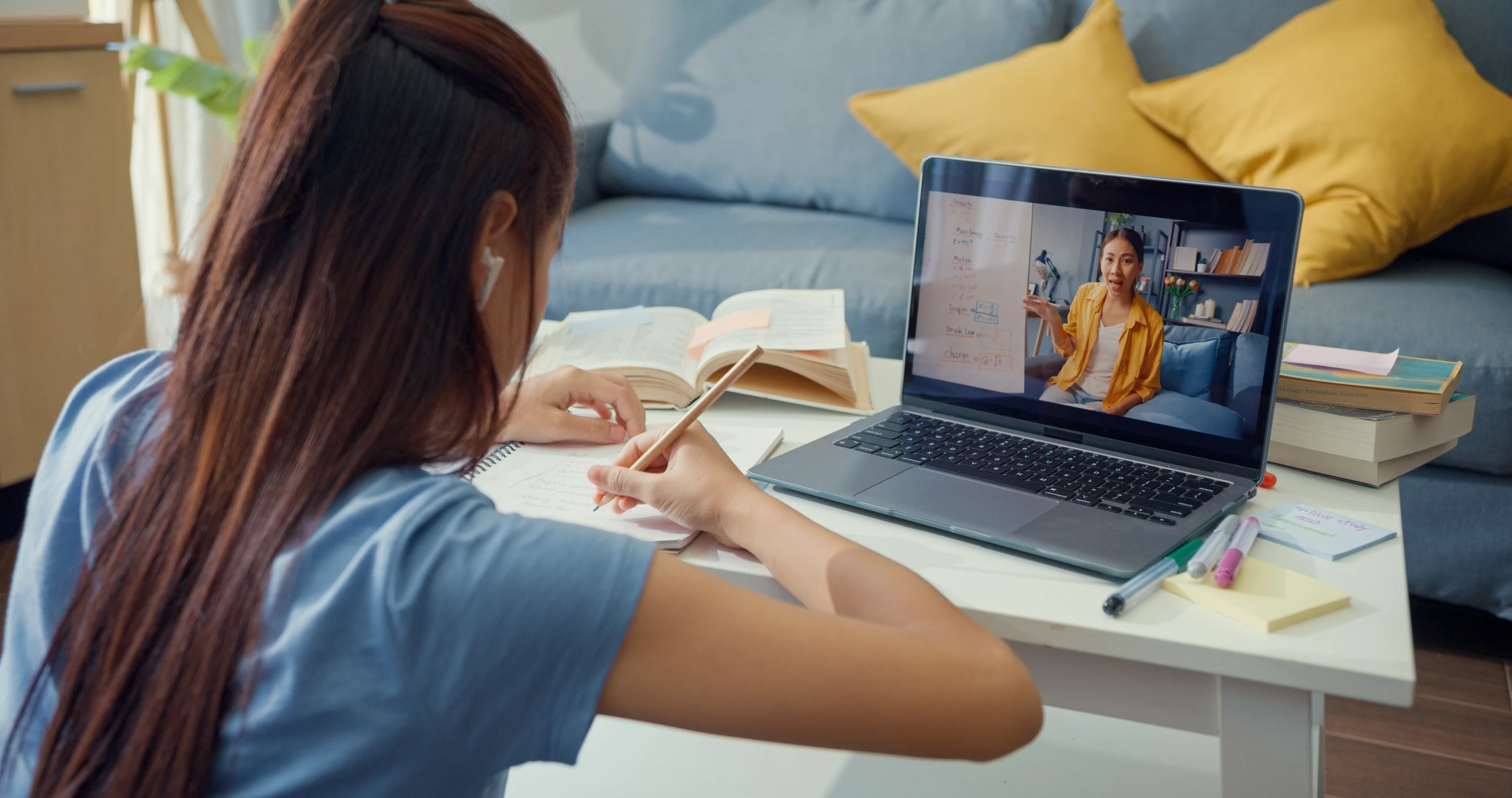 eLearning mit der Filmproduktion Panda Pictures aus München und Ulm.  Klassische eLearning Situation. Darstellerin im Homeoffice kniet vor Couchtisch mit Laptop darauf. Zu sehen ein eLearning Format wie Masterclass, wo eine Experte etwas erklärt.