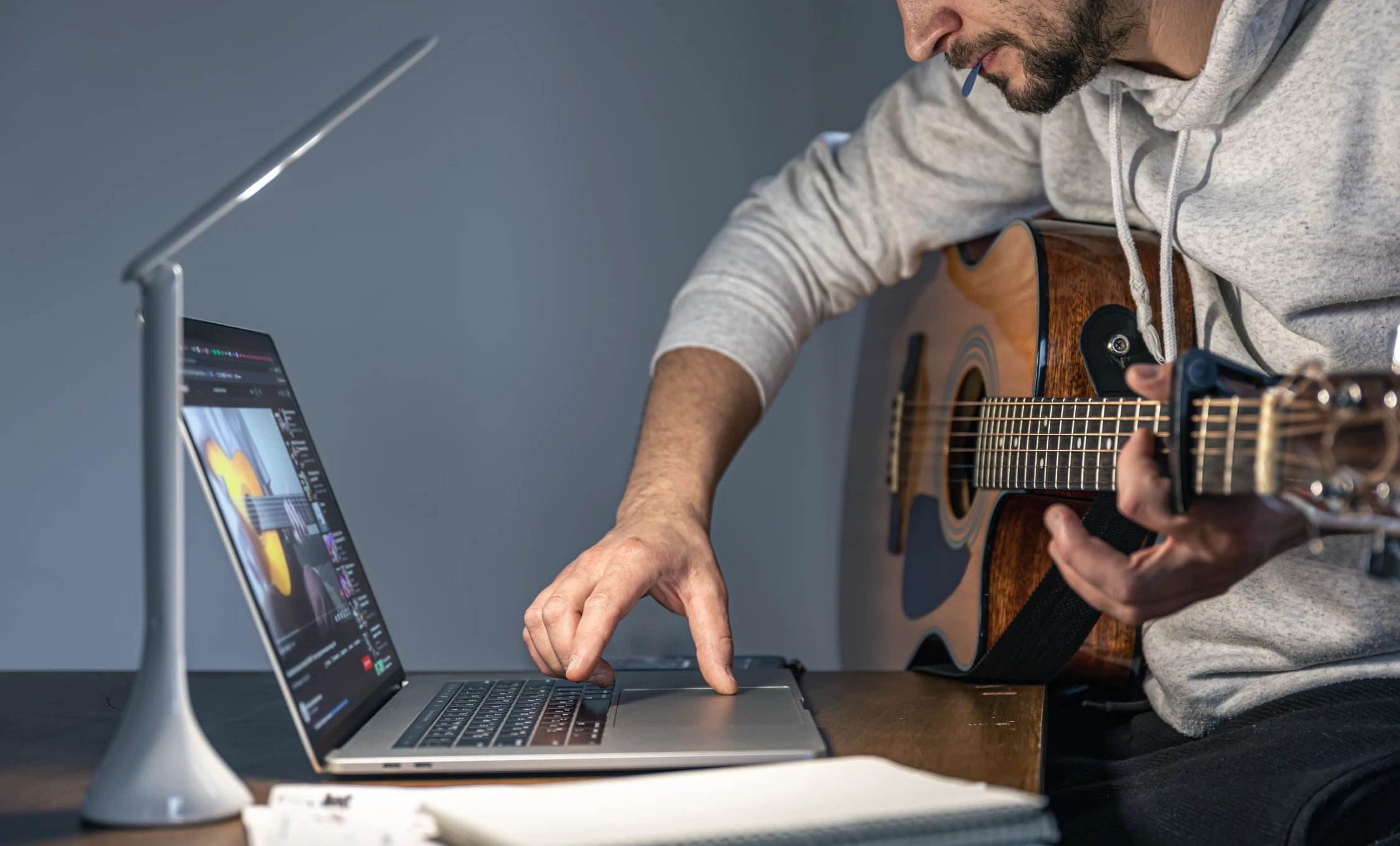 Tutorial Videos mit der Filmproduktion Panda Pictures aus München und Ulm. Gitarrenspieler der mit einem Tutorial auf dem Laptop lernt.