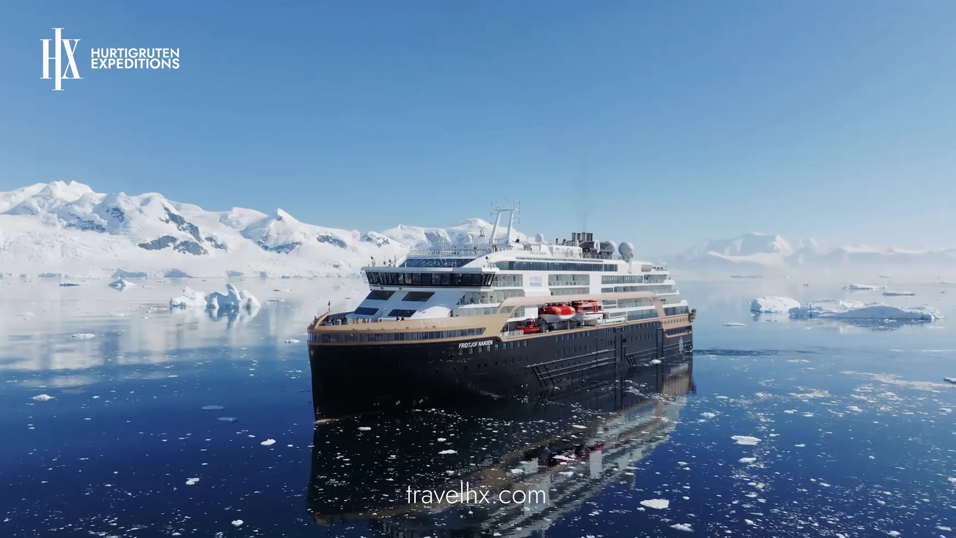 Kreuzfahrtschiff "Fridtjof Nansen" von Hurtigruten fährt durch eisiges Wasser vor schneebedeckten Bergen. Diese eindrucksvolle Expeditionsaufnahme zeigt die visuelle Qualität der Panda Pictures Filmproduktion München Ulm Videoproduktion.