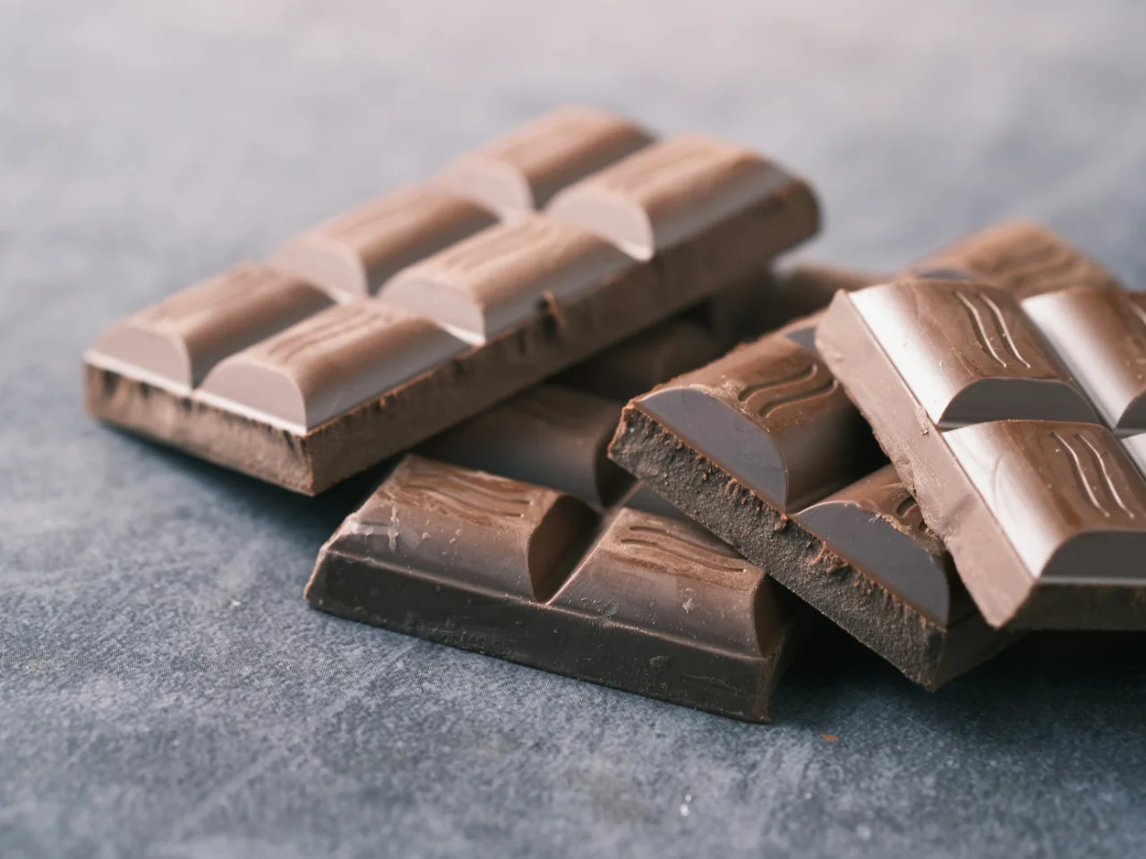 Bar of dark chocolate on a black table, which contains theobromine toxic to dogs