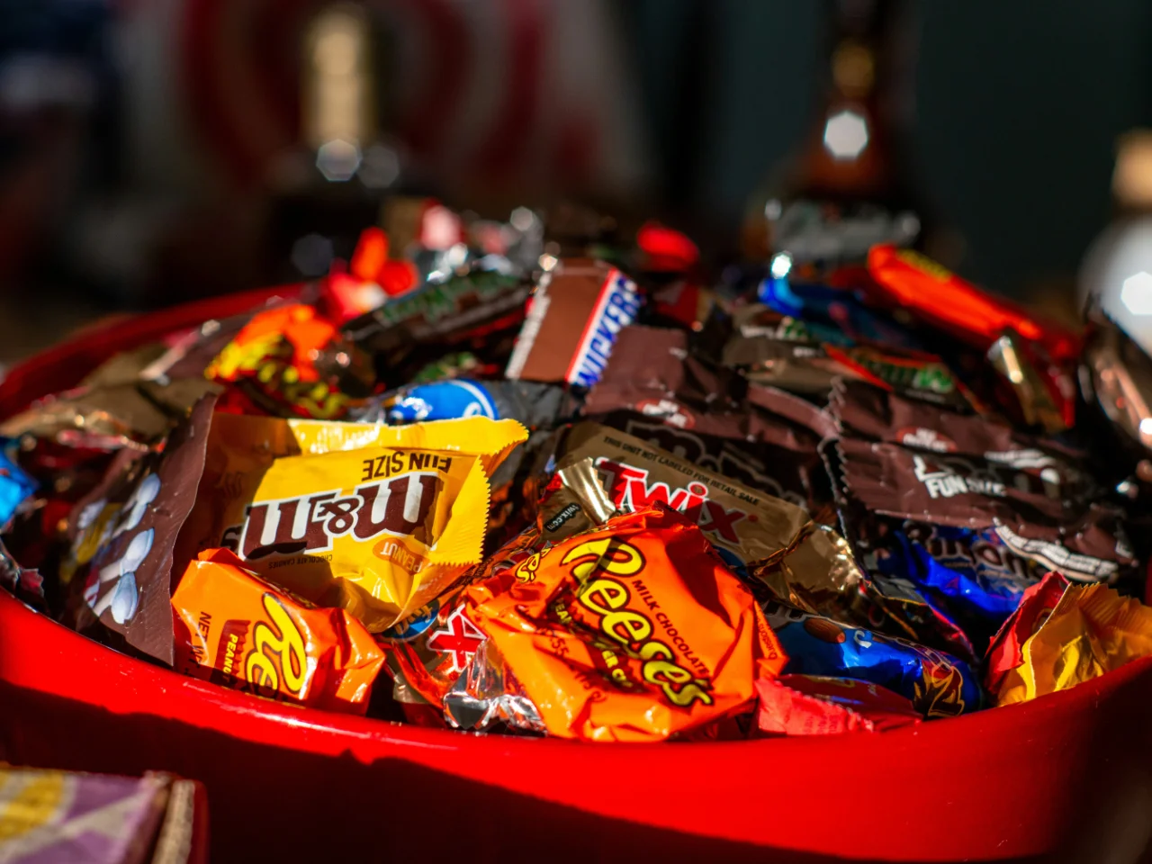 Red bowl full of Halloween candy that should be kept out of a dog's reach