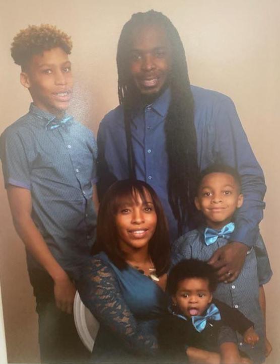 A family of four poses for a picture.