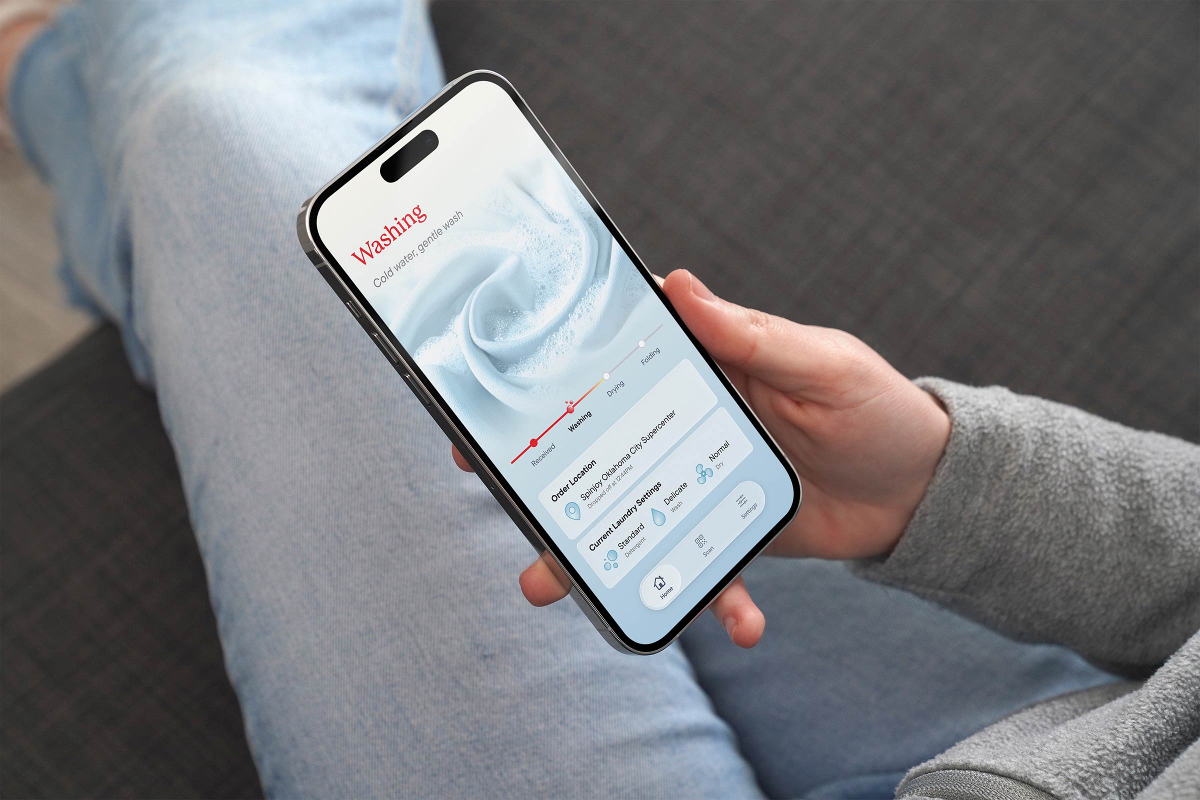 Person holding phone with the app showing laundry is being washed