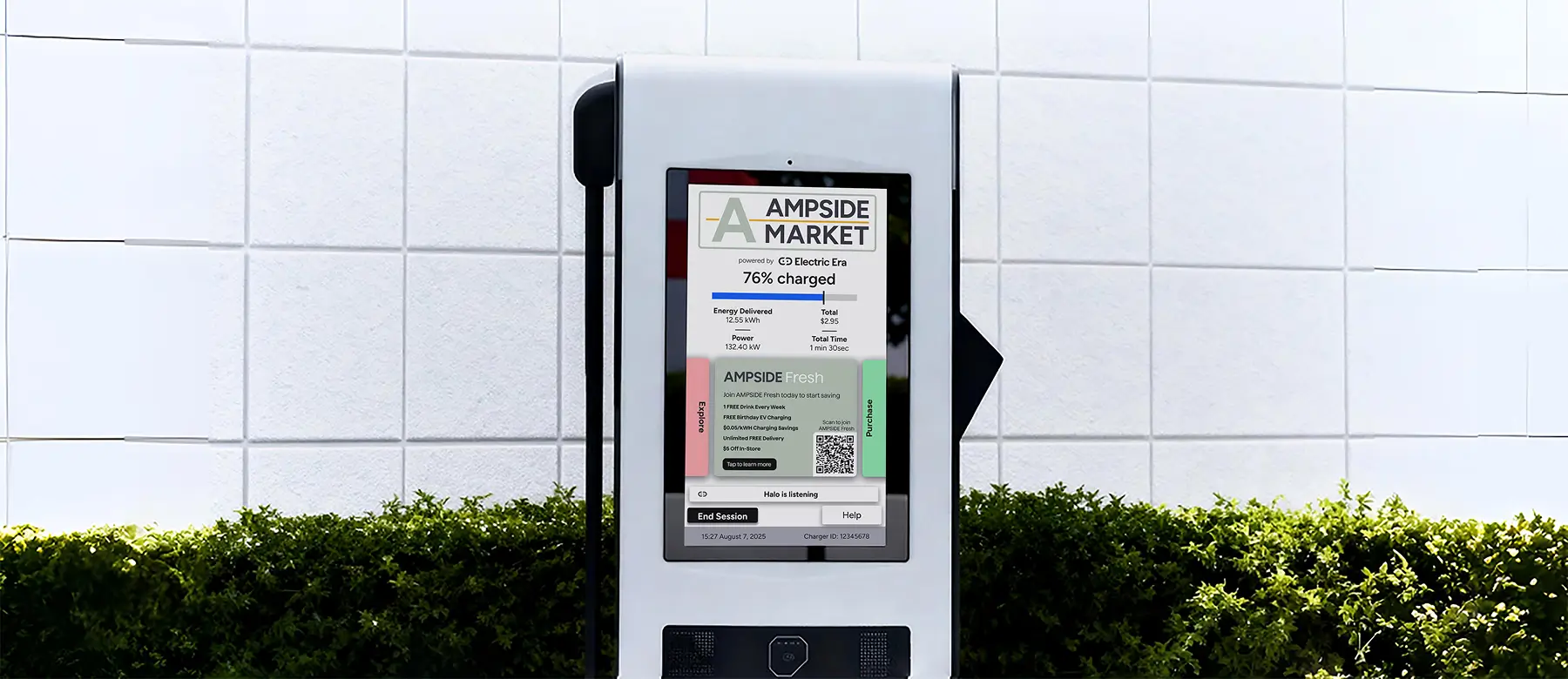 An EV charger with a screen displaying the charging details, including 76% charge, energy delivered, total cost, and the AMPSIDE Fresh membership offer. The background is a white tiled wall with greenery at the bottom