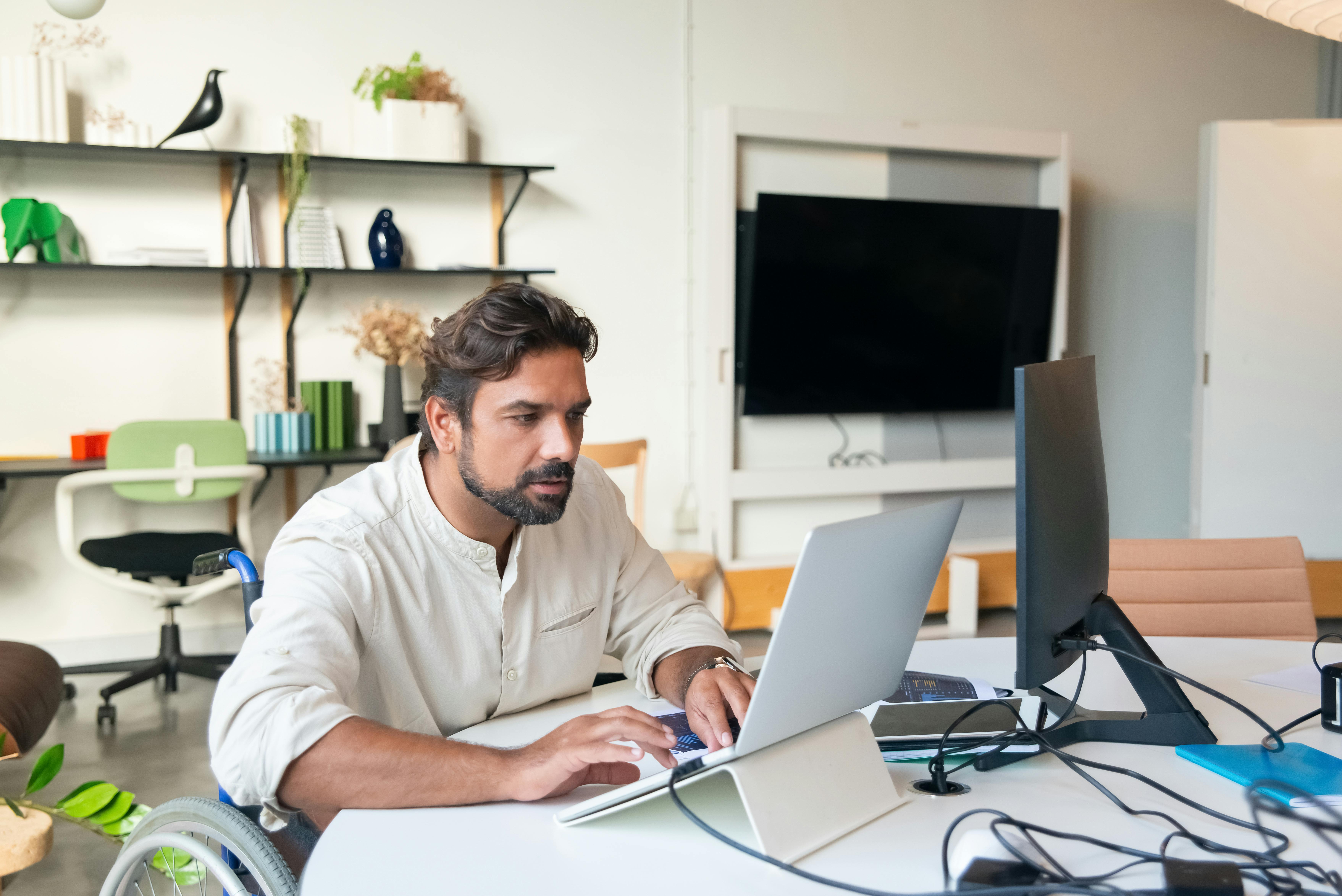 Professional working at a laptop and monitor in an office