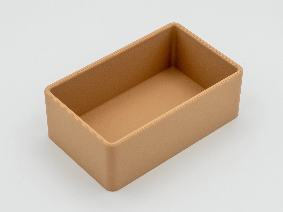 Single empty tan-colored rectangular drawer organizer with rounded corners, shown on a white background.