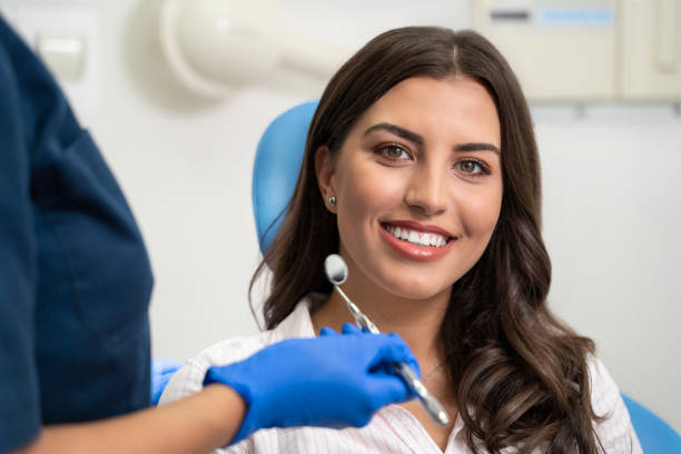 Young woman with gorgeous smile at dentist Young woman with gorgeous smile at dentist, looking at camera female patient smiling at dental appointment stock pictures, royalty-free photos & images