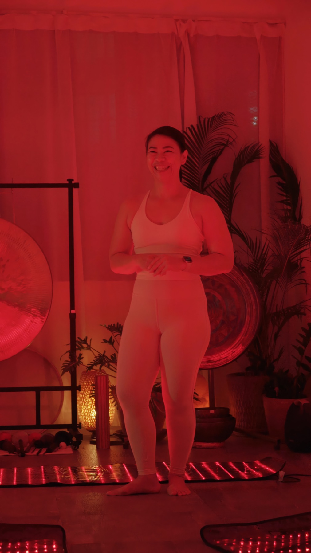 Kru Nada in a red-lit yoga studio