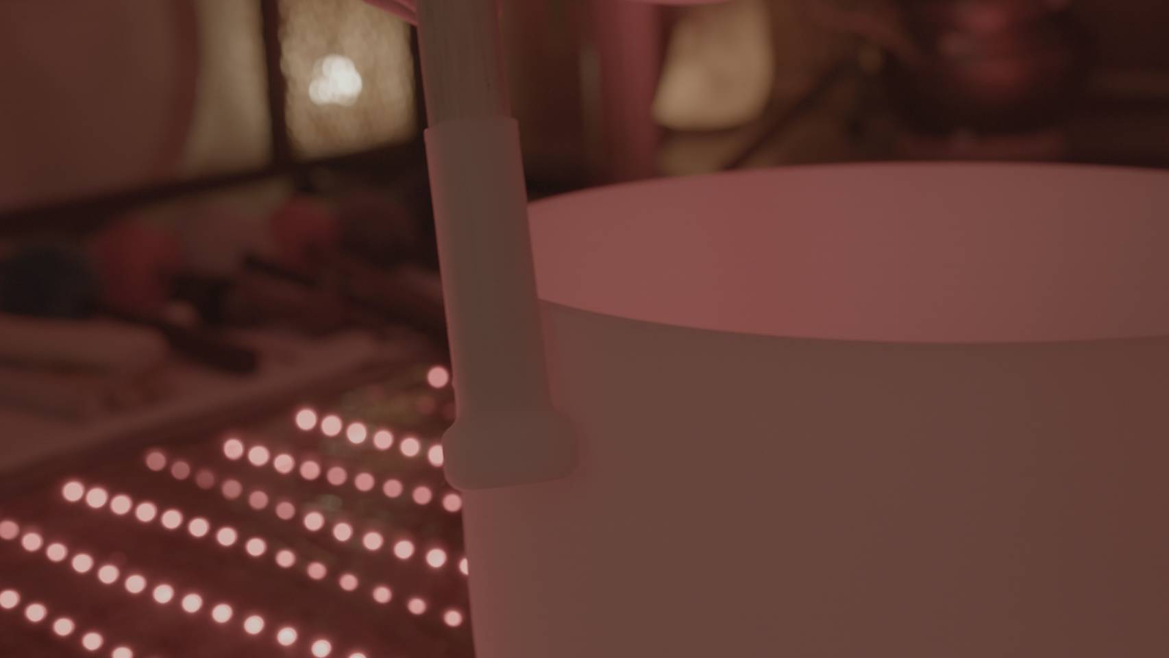 A singing bowl beside a red-light yoga mat with its LEDs illuminated
