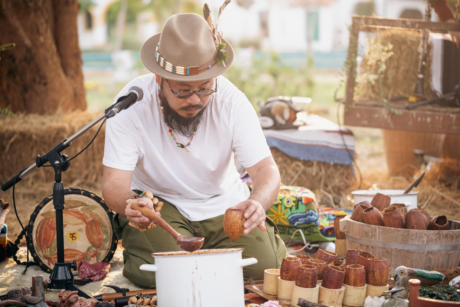 Cacao facilitator preparing drinks beside a microphone