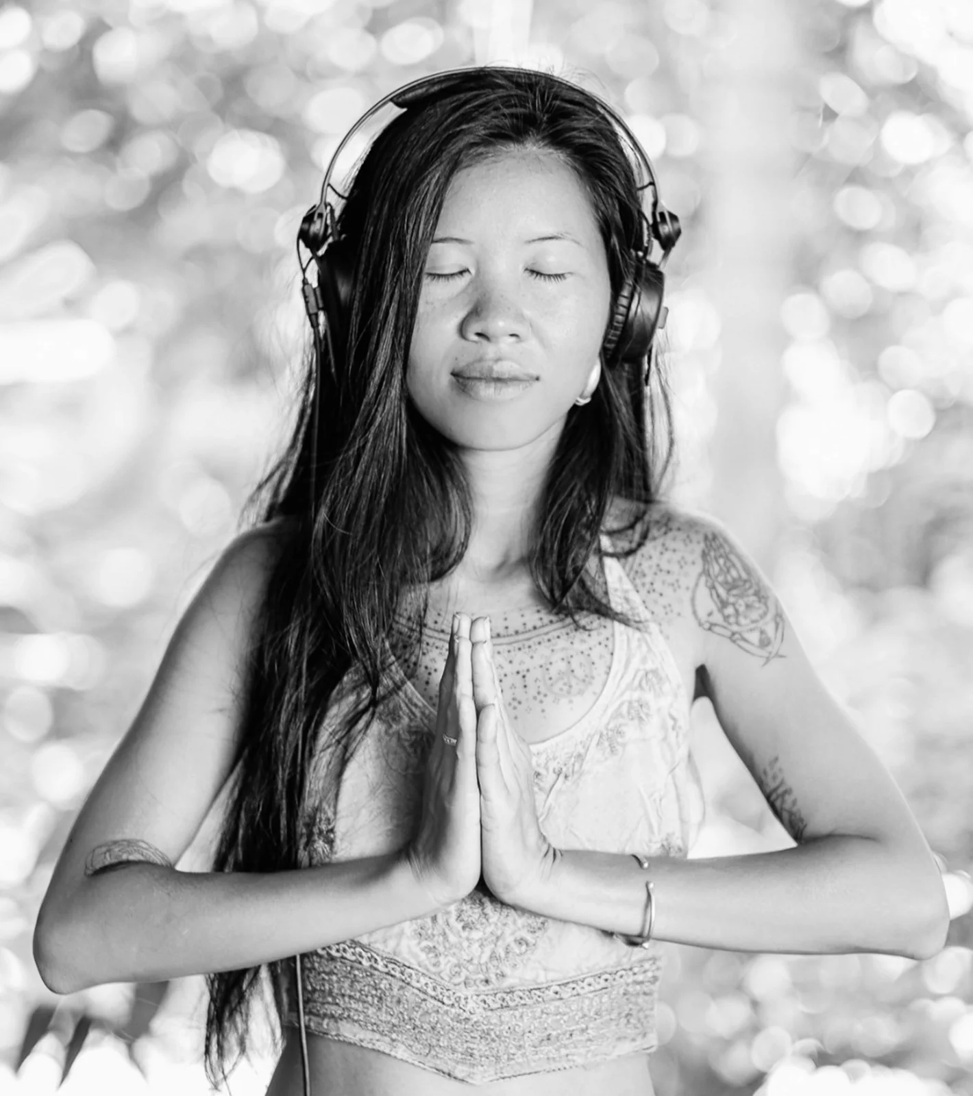 Woman outdoors with her eyes closed and palms together