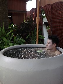 A guest relaxing in a round cold-plunge tub