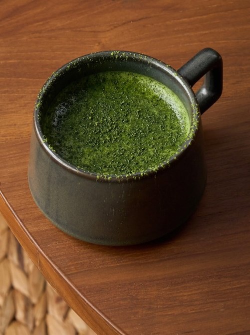 A cup of matcha on a wooden table