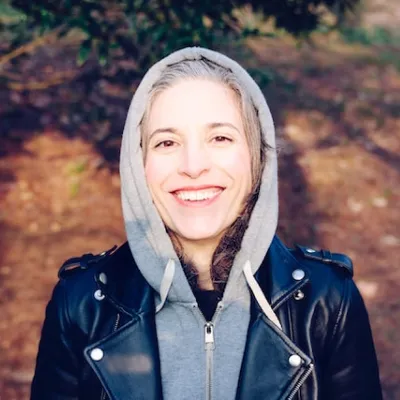 A woman wearing a black jacket and a gray hoodie.