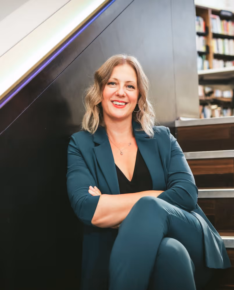 Headshot of Kate Rostance wearing a beautiful teal suit
