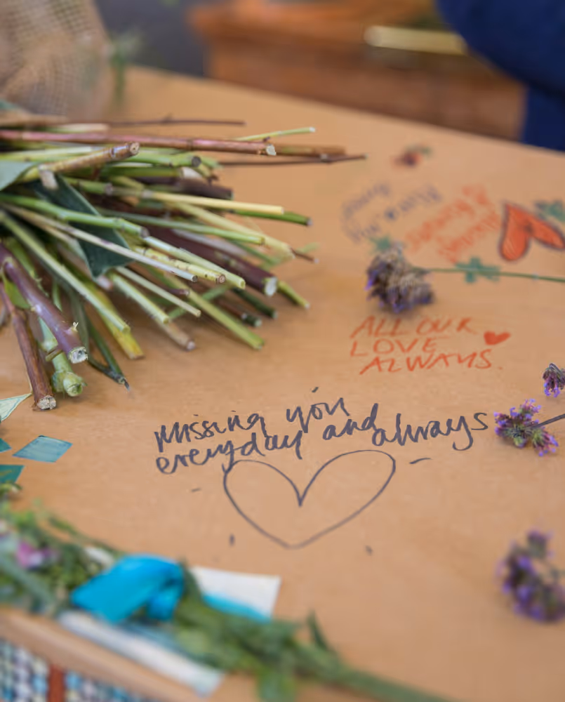 Written messages on a cardboard coffin, photo by Good Funeral Guide on Unsplash