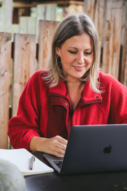 Kate Rostance Celebrant writing a funeral ceremony on a laptop