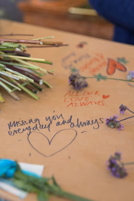 Written messages on a cardboard coffin, photo by Good Funeral Guide on Unsplash