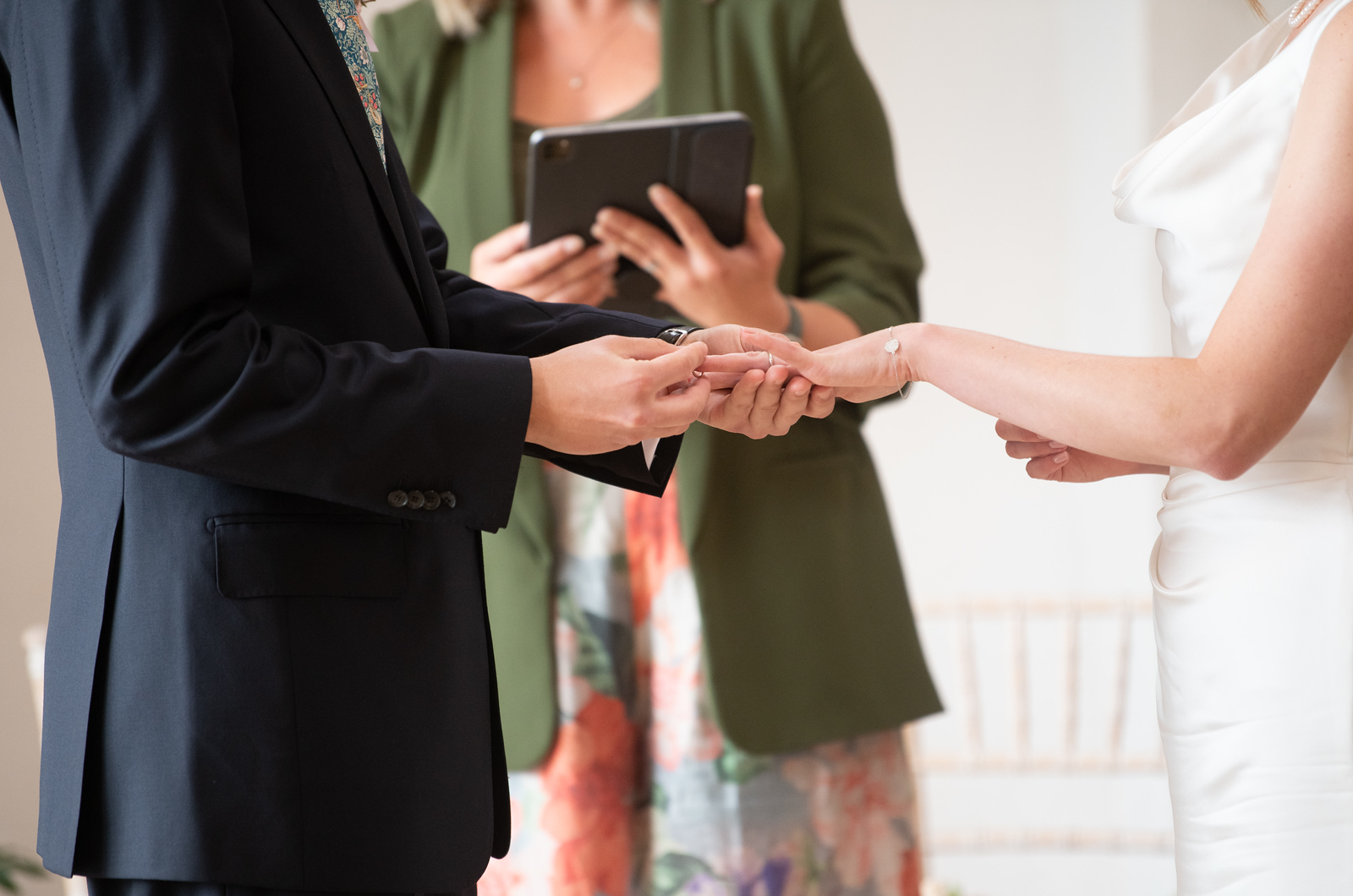 Close-up of David placing a wedding ring on Emily’s finger during their Talhenbont Hall ceremony, conducted by celebrant Kate Rostance.