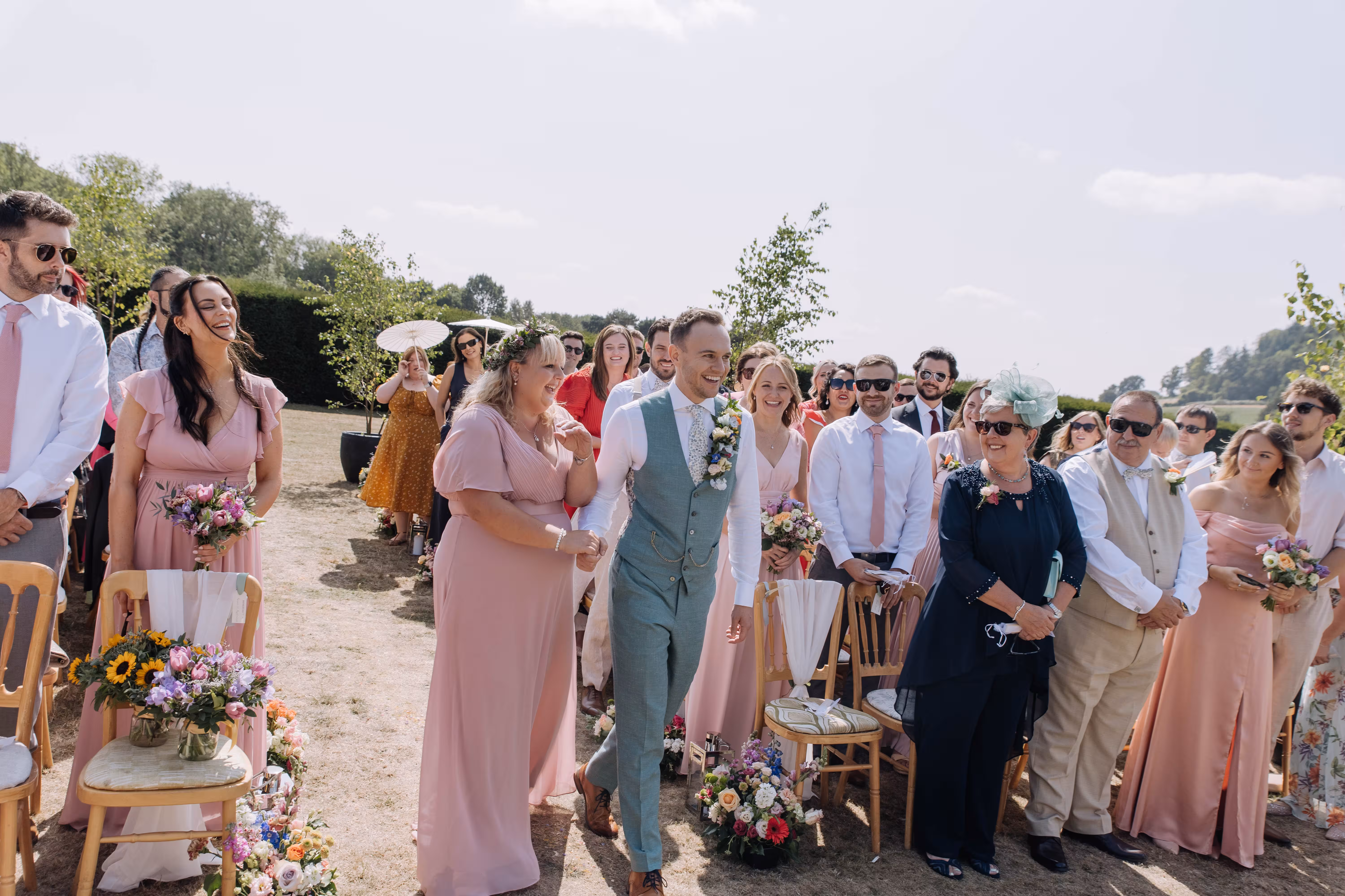 Groom Dan walks down the aisle with family and friends at Brinsop Court wedding.