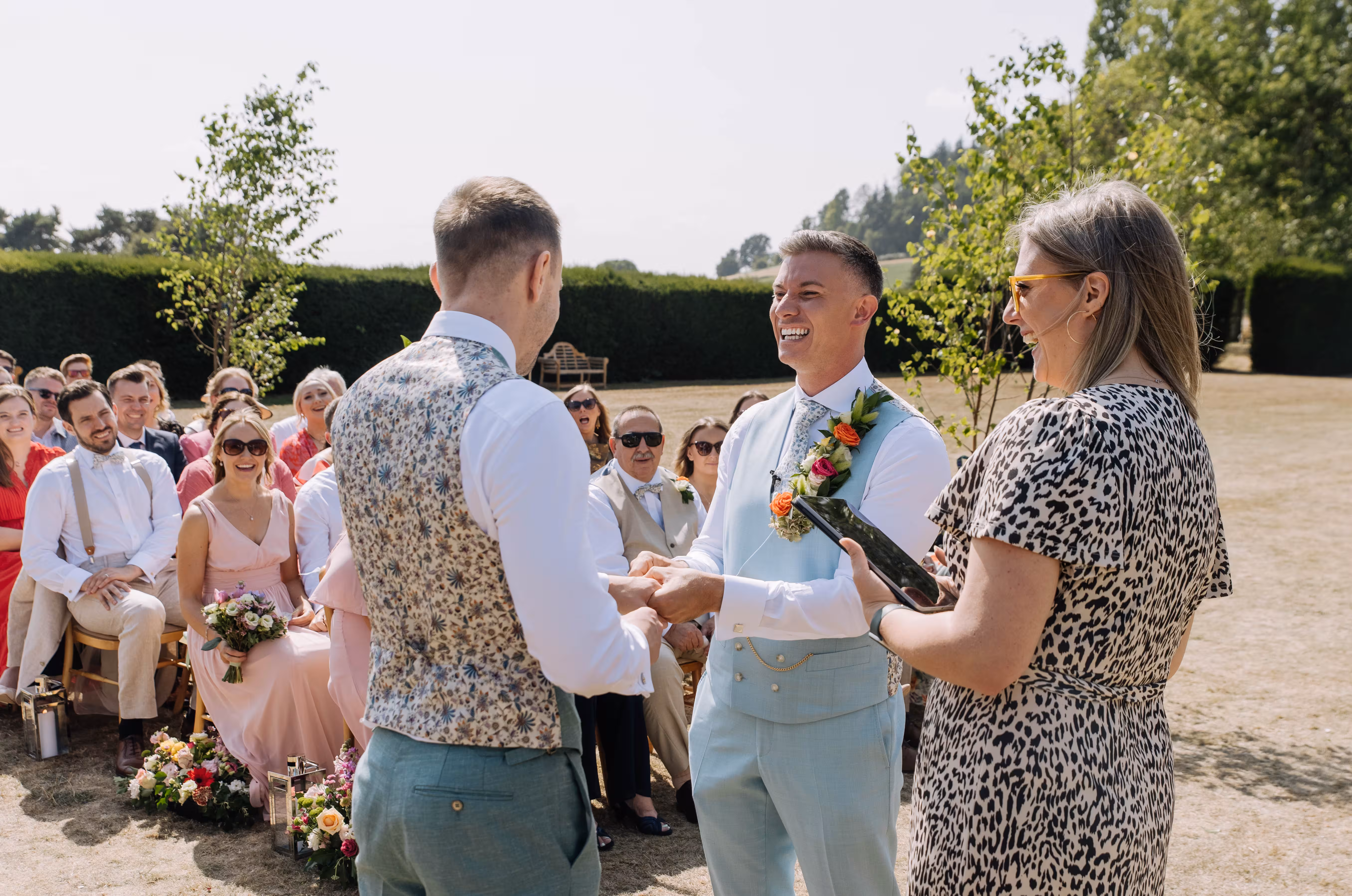 Celebrant leads vows as Rod and Dan exchange rings at Brinsop Court wedding.