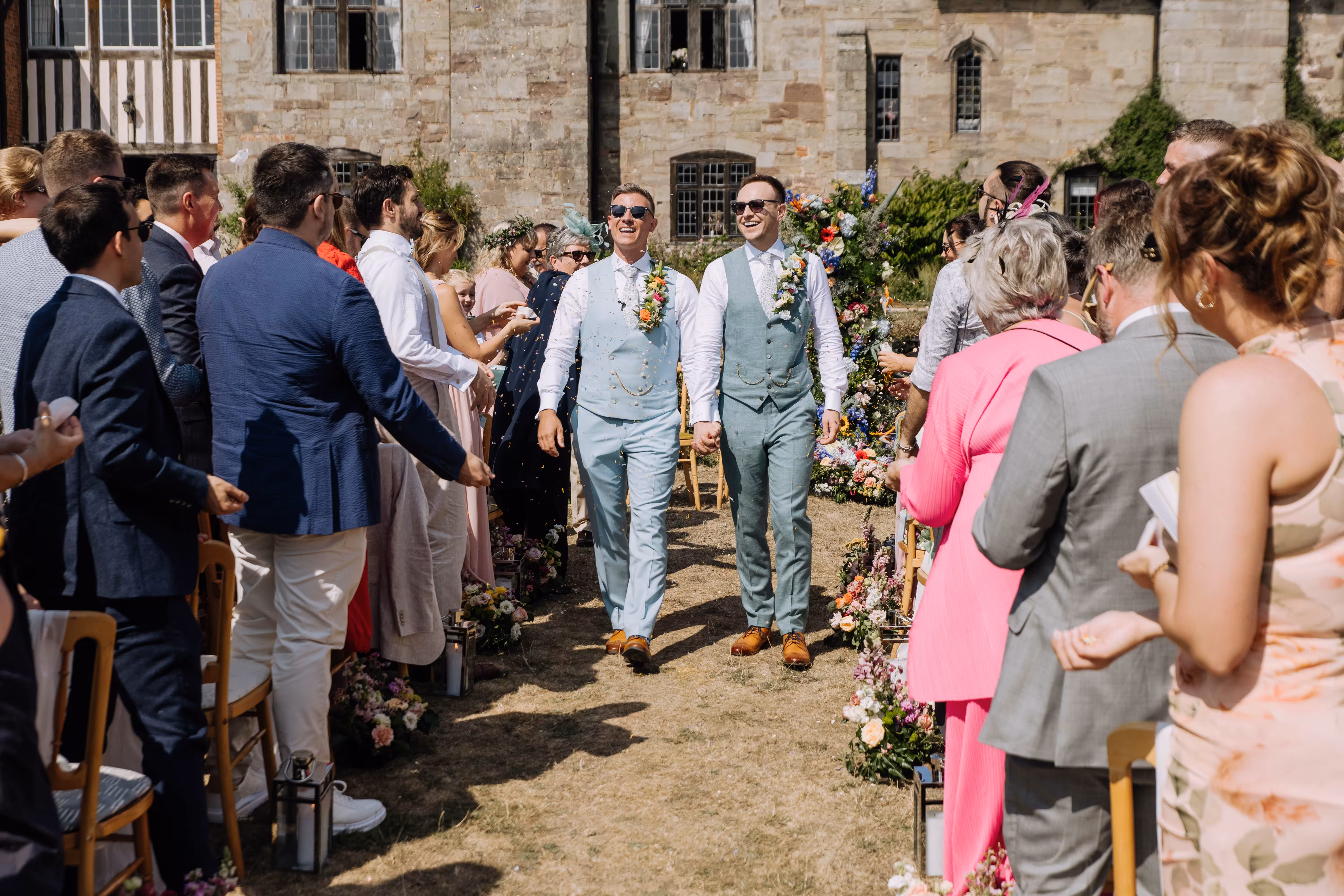 Confetti toss for grooms Rod and Dan walking back up the aisle at Brinsop Court.