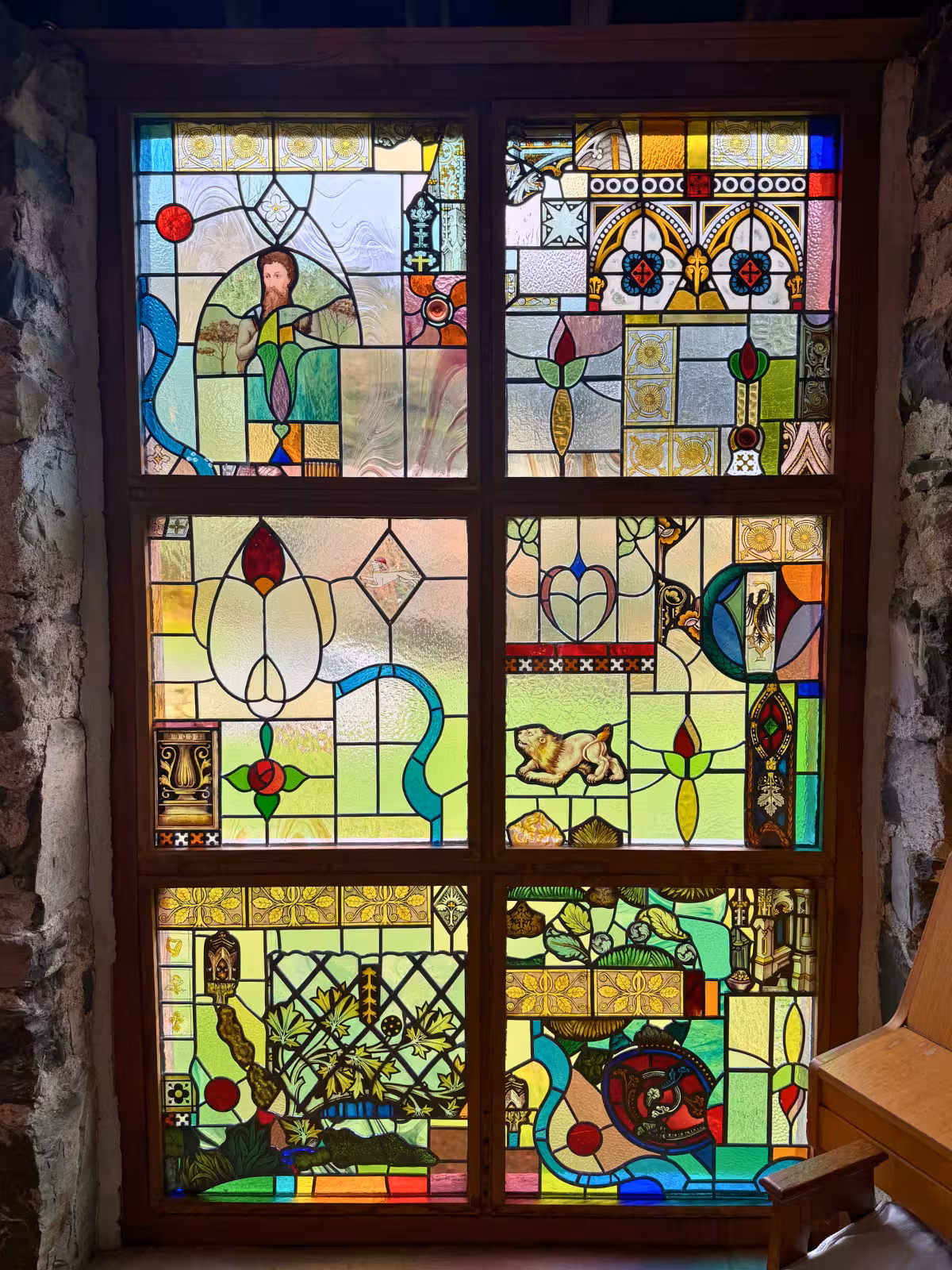 Stained glass window inside Llyn Gwynant Barns, adding colour and light to Clair and Janine’s humanist wedding ceremony in Gwynedd.