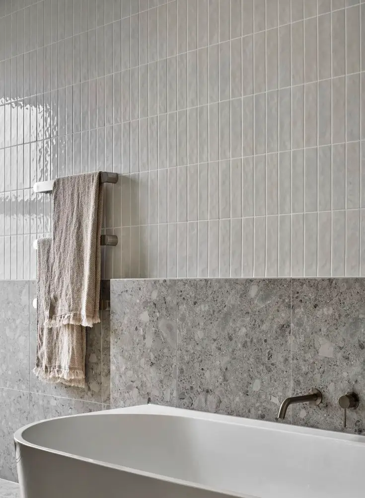 Contemporary bathroom showing a bath tub with grey and white contrast tiles