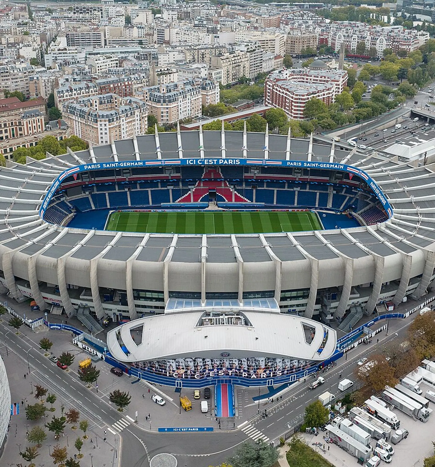 Aerial view of the Paris Saint-Germain football stadium showing the green field, seating area, and surrounding city buildings.