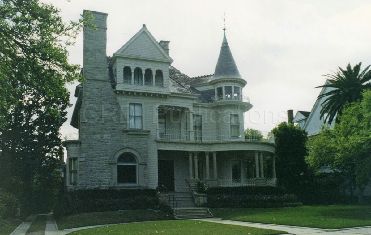A Queen-Anne Victorian home with a fancy brick chimney and a circular tower.