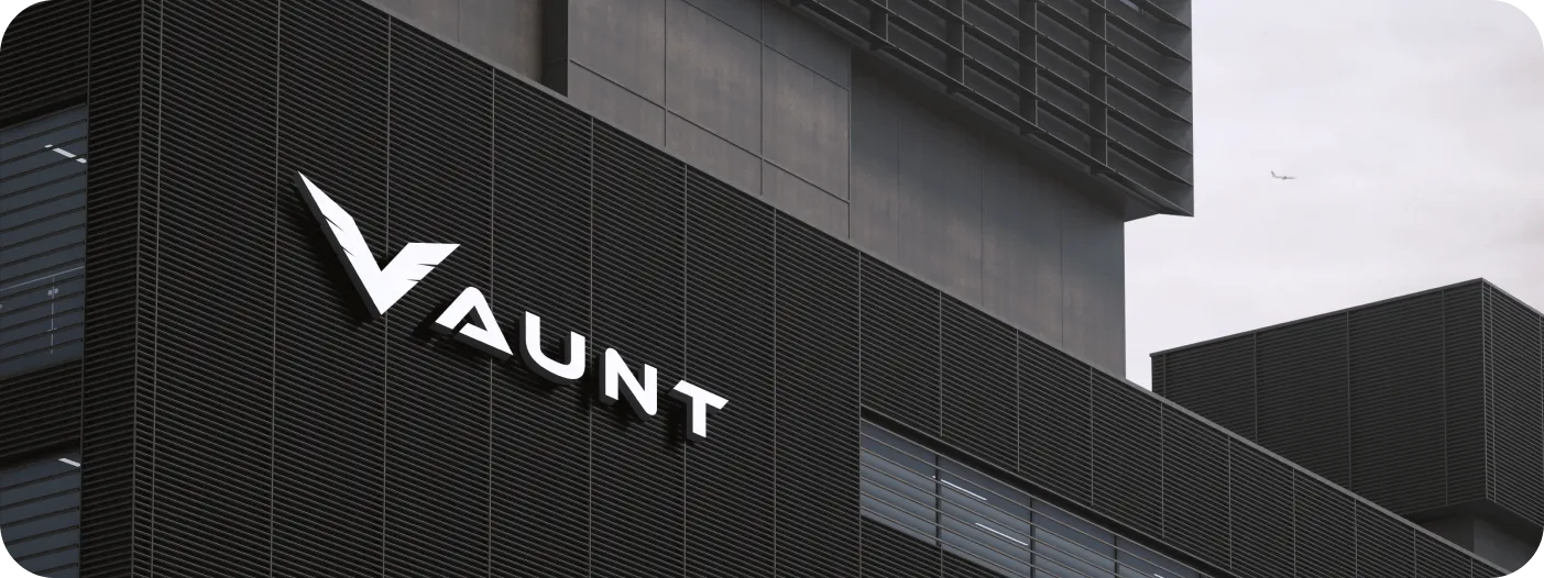 Modern office building exterior with black horizontal slats and a large white sign reading 'VAUNT'.