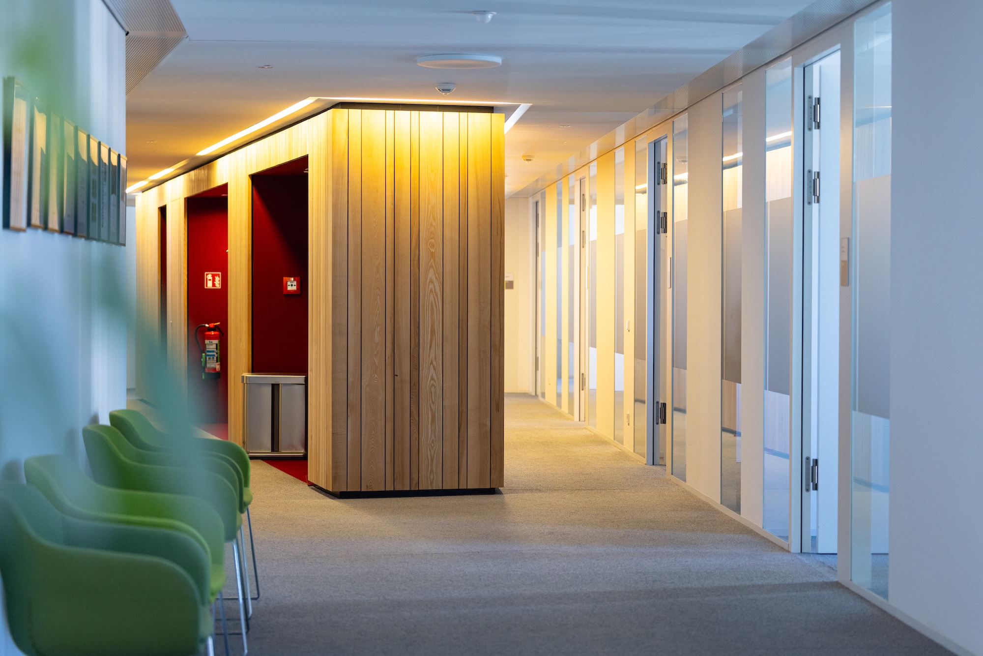 Heller Büroflur mit Türen und Beleuchtung.