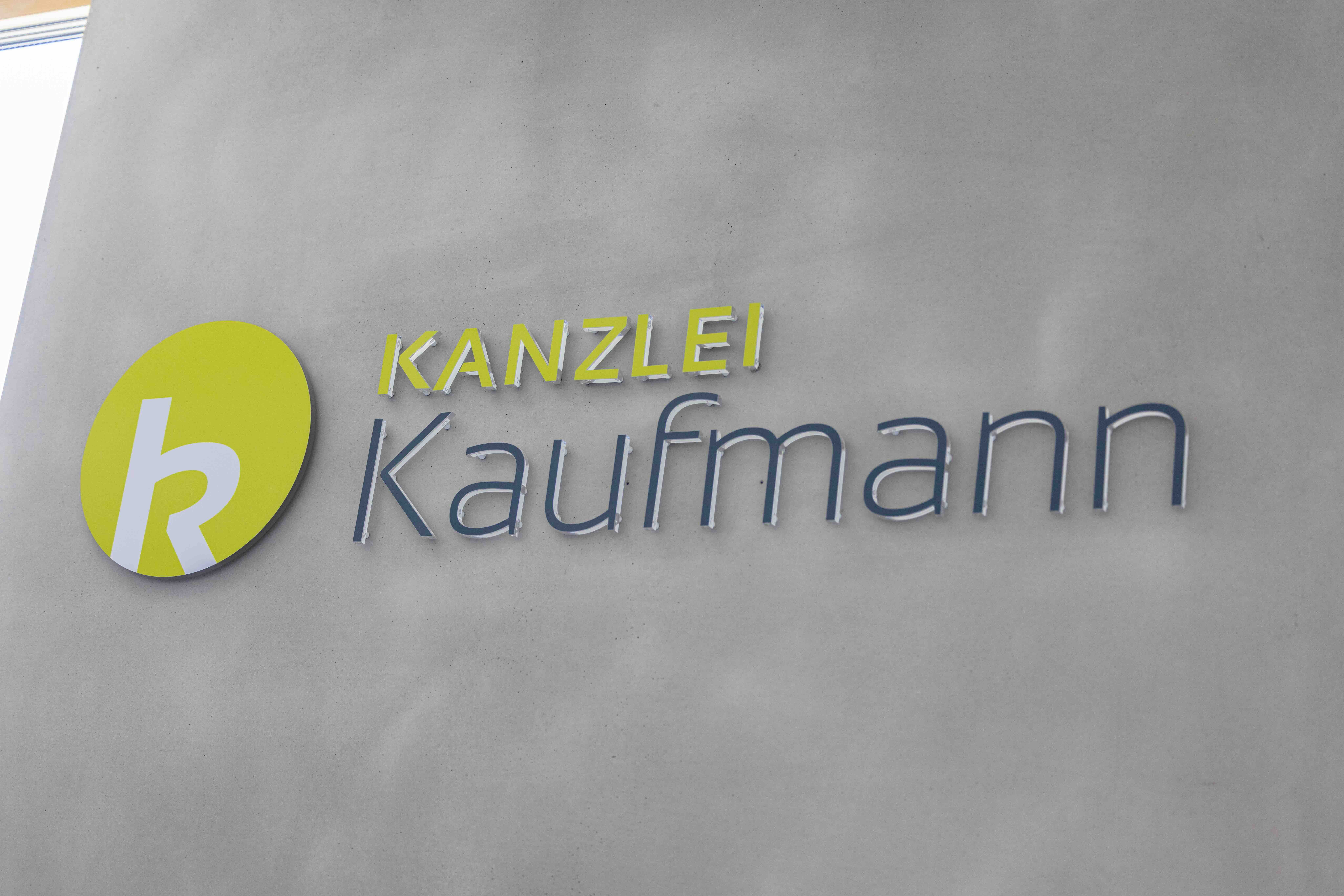 Logo der Kanzlei Kaufmann auf Glaswand.