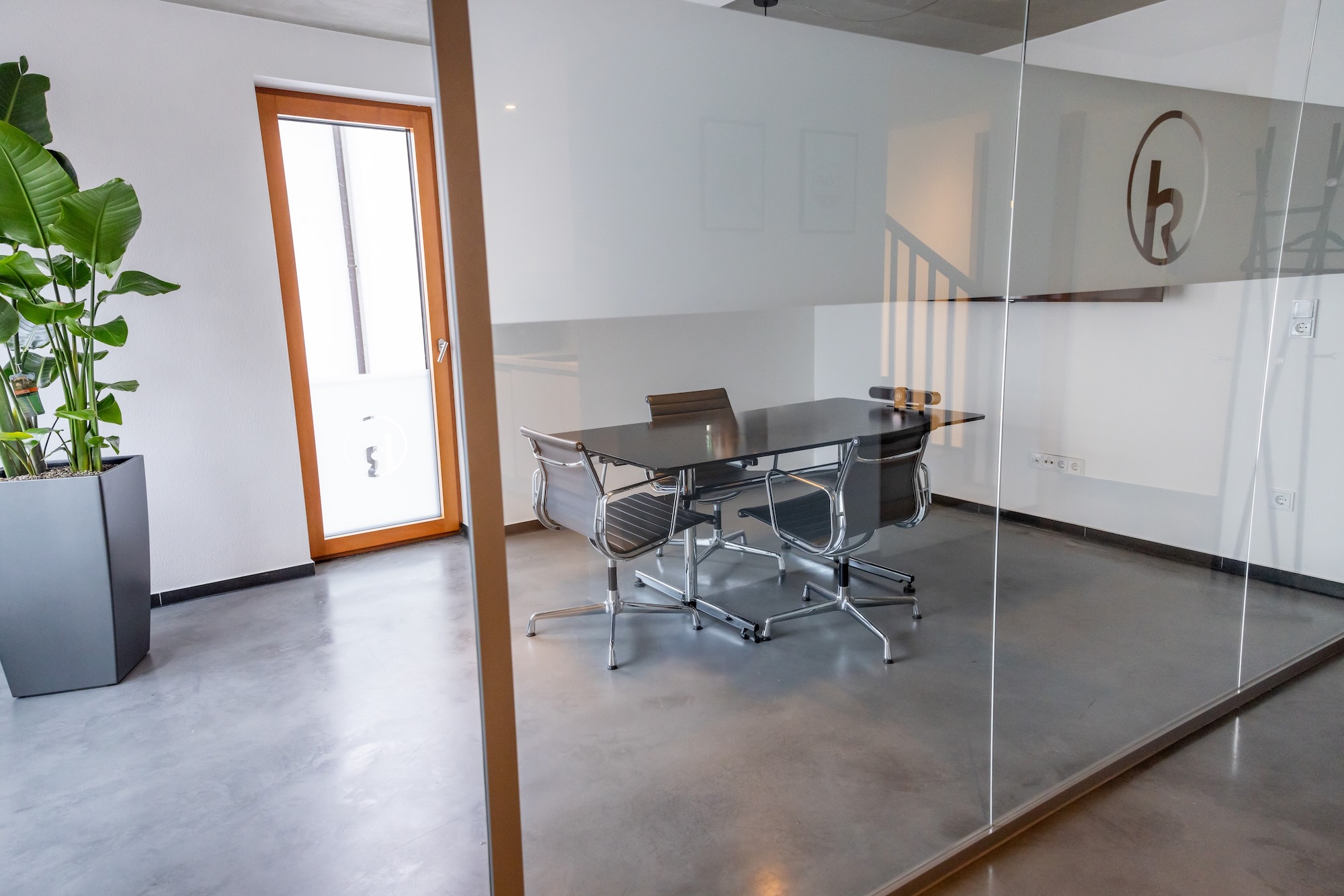 Heller Konferenzraum mit großem Tisch und Stühlen.