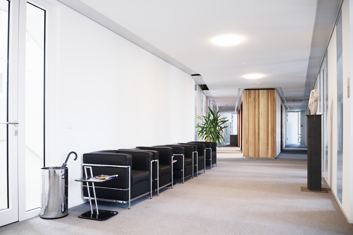 Modernes Büro mit hellem Flur und Sitzbereich.
