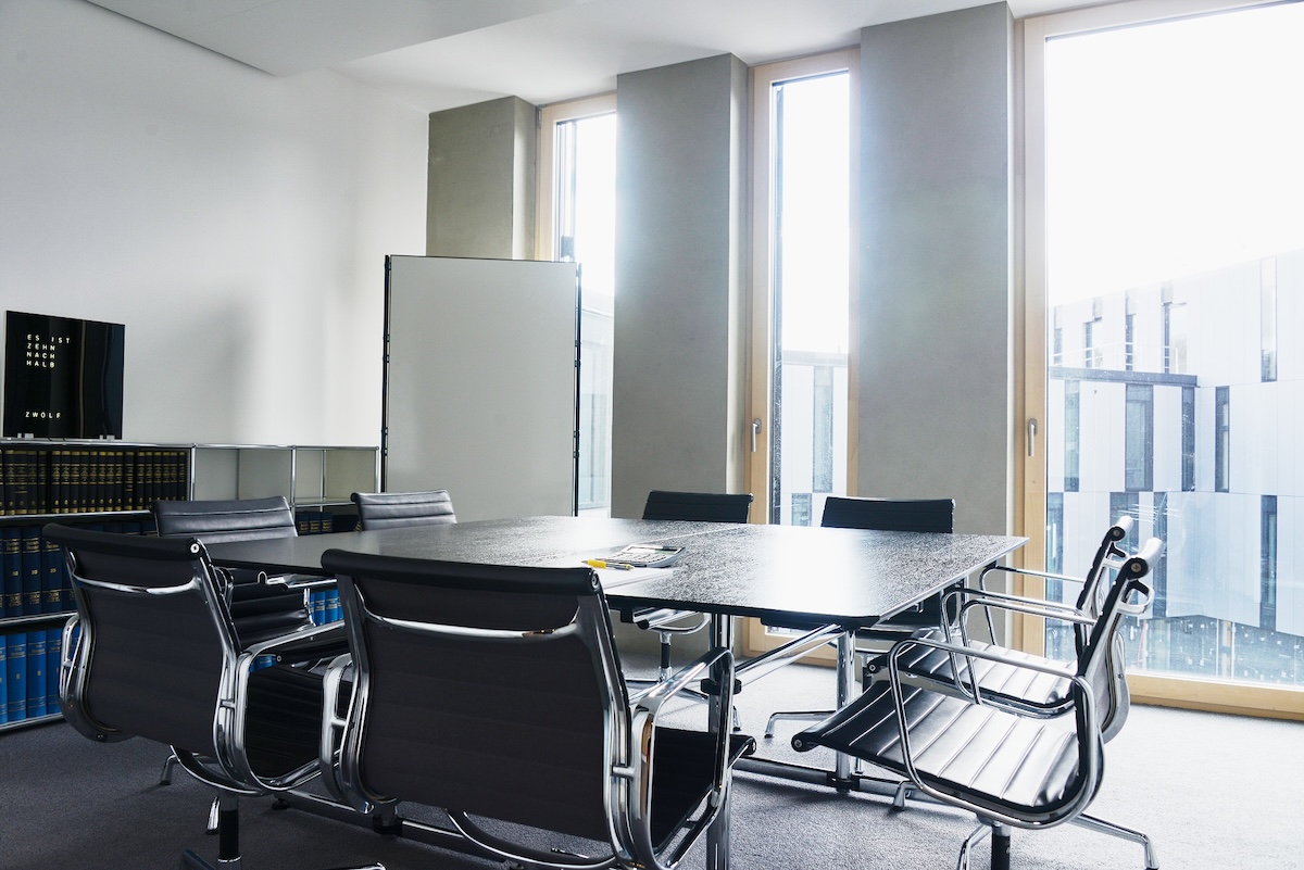 Moderner Besprechungsraum mit Tisch und Stühlen.