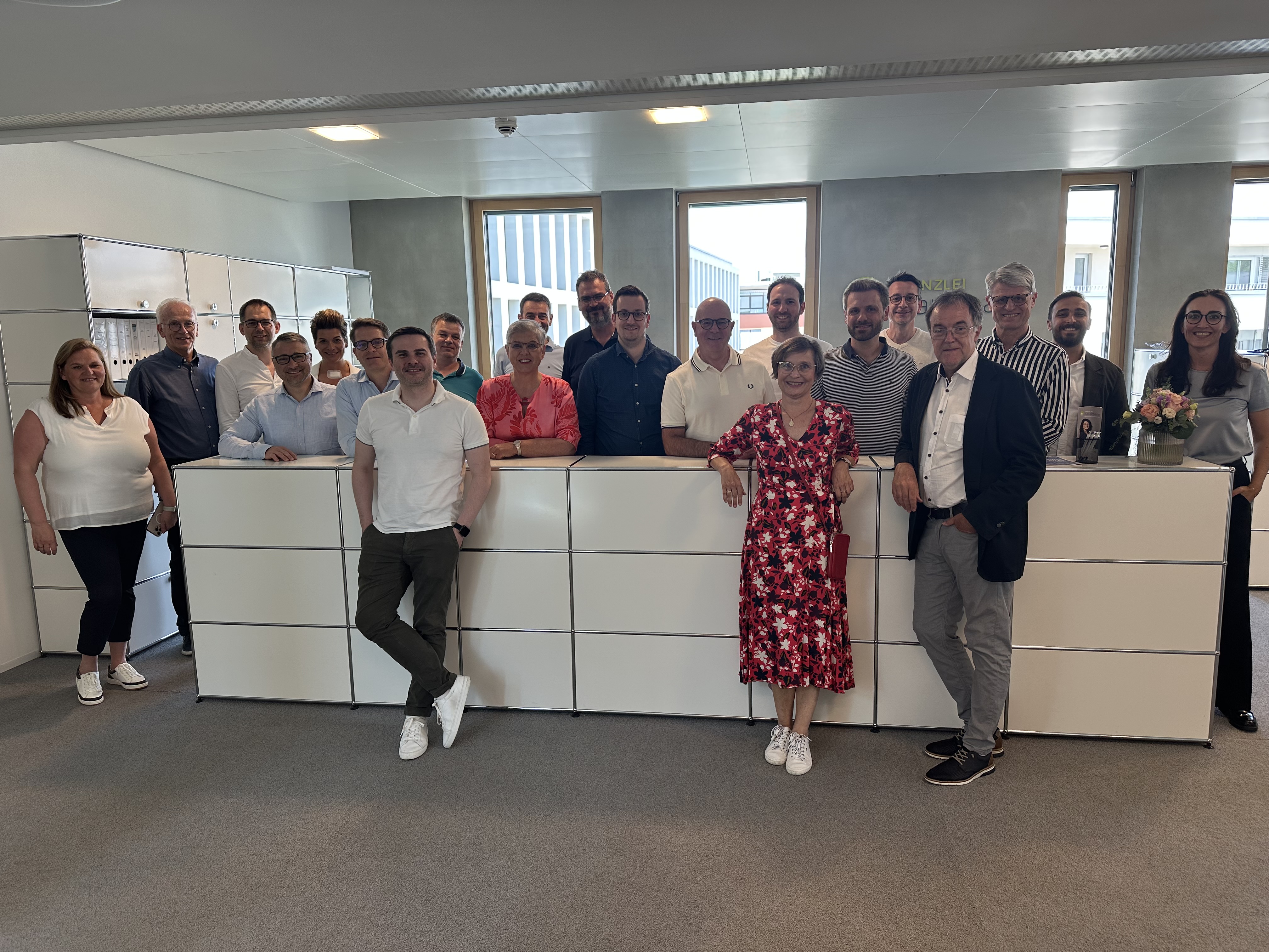 Gruppenfoto in einem Innenraum, mehrere Personen stehen nebeneinander.