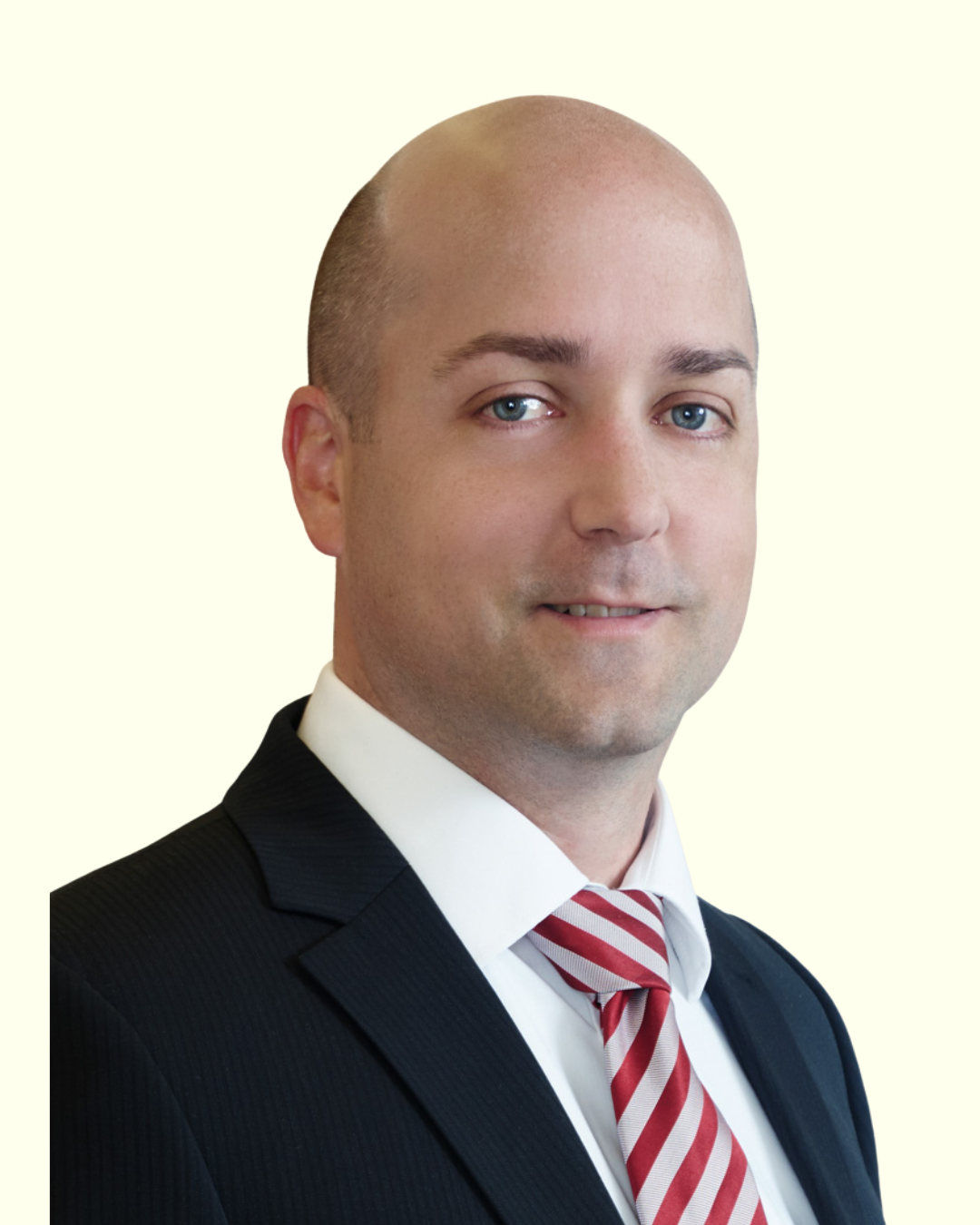 Porträt eines Mannes im Anzug vor hellem Hintergrund.