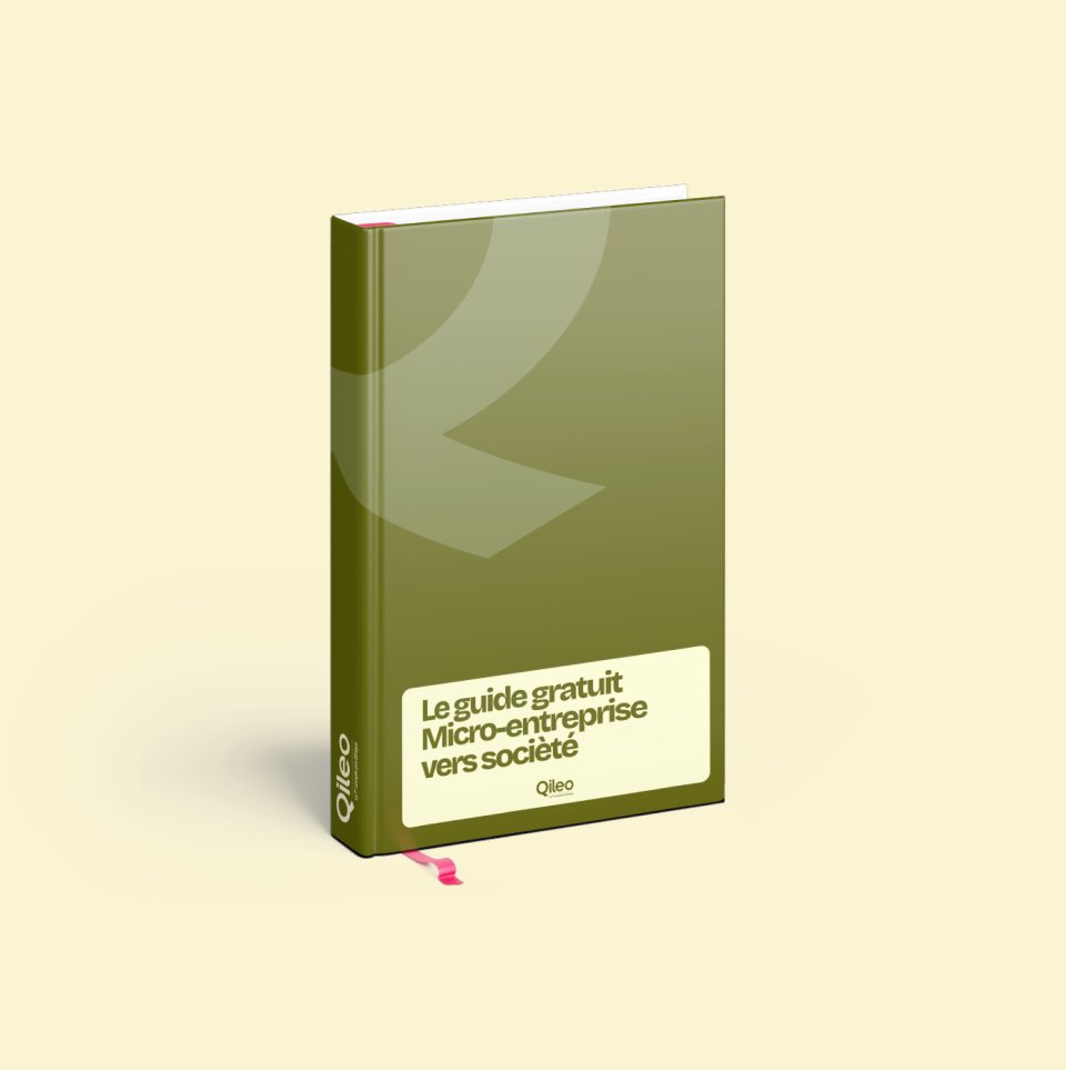 Livre vert avec un signet rose intitulé « Le guide gratuit Micro-entreprise vers société » de Qileo.