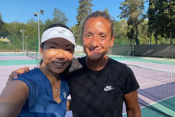 Tess Liu smiling and standing next to a female tennis player.