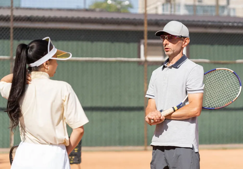 Two tennis players in conversation with each other on the court.