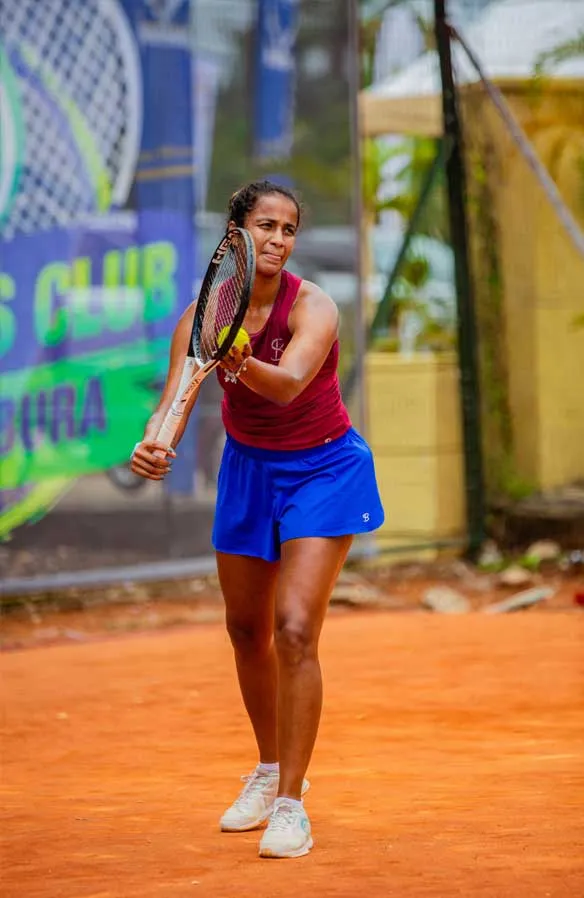 Female tennis player preparing to serve the ball.