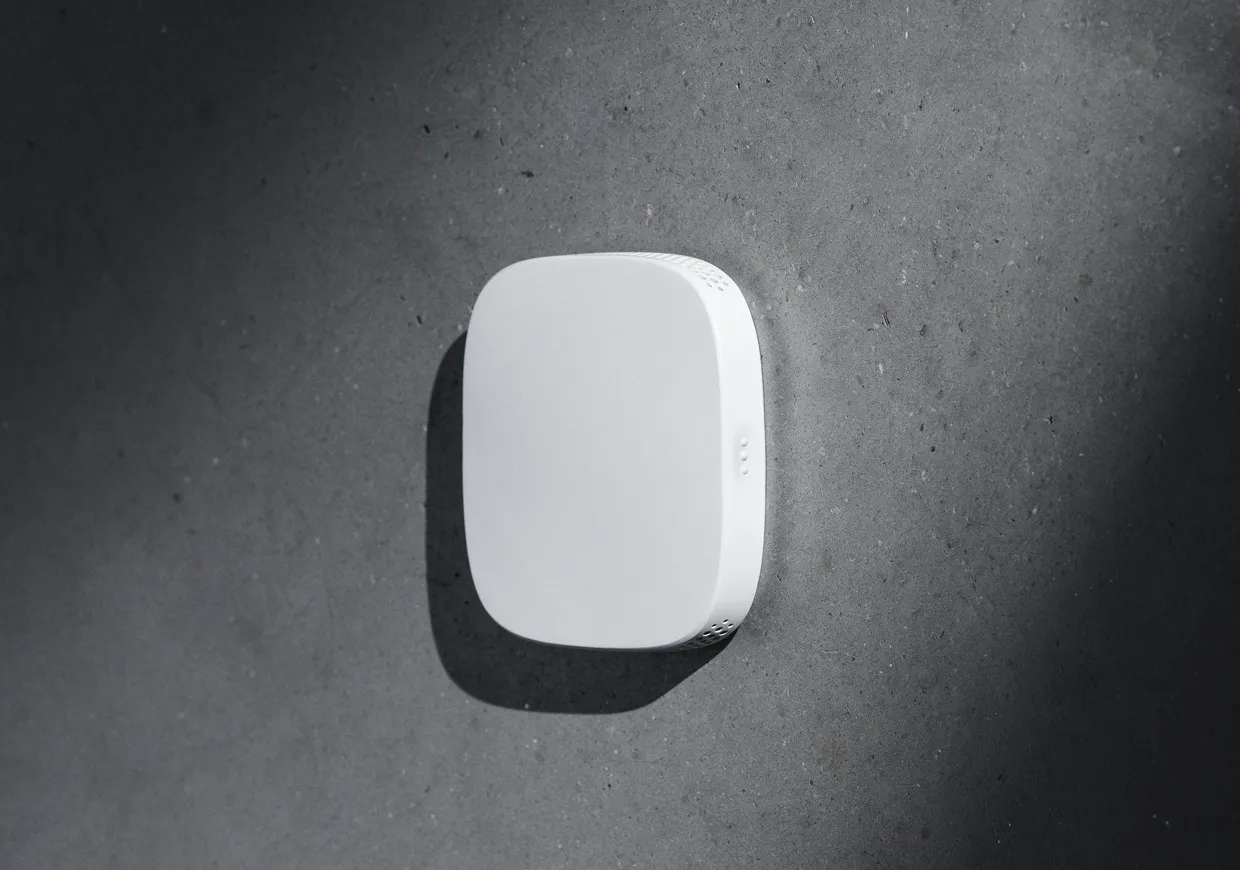 White Alledio multi-sensor mounted on a concrete wall