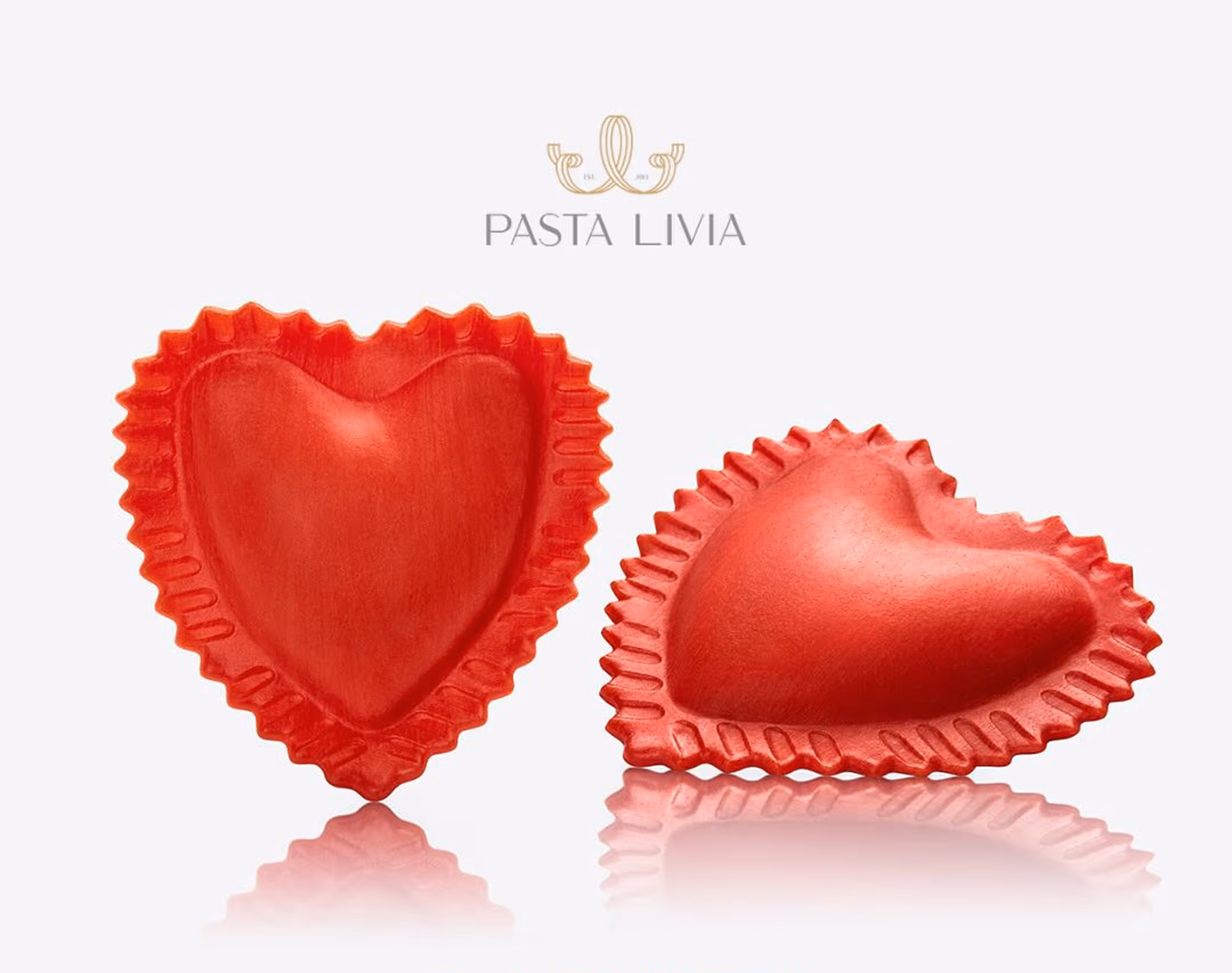 Two red heart-shaped pasta pieces with ruffled edges and a smooth surface, reflecting below on a white background under the Pasta Livia logo.
