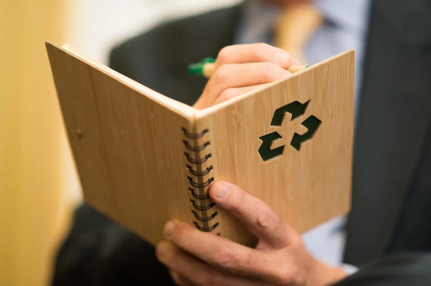 photo d'une personne qui tient un livre avec un logo recyclage