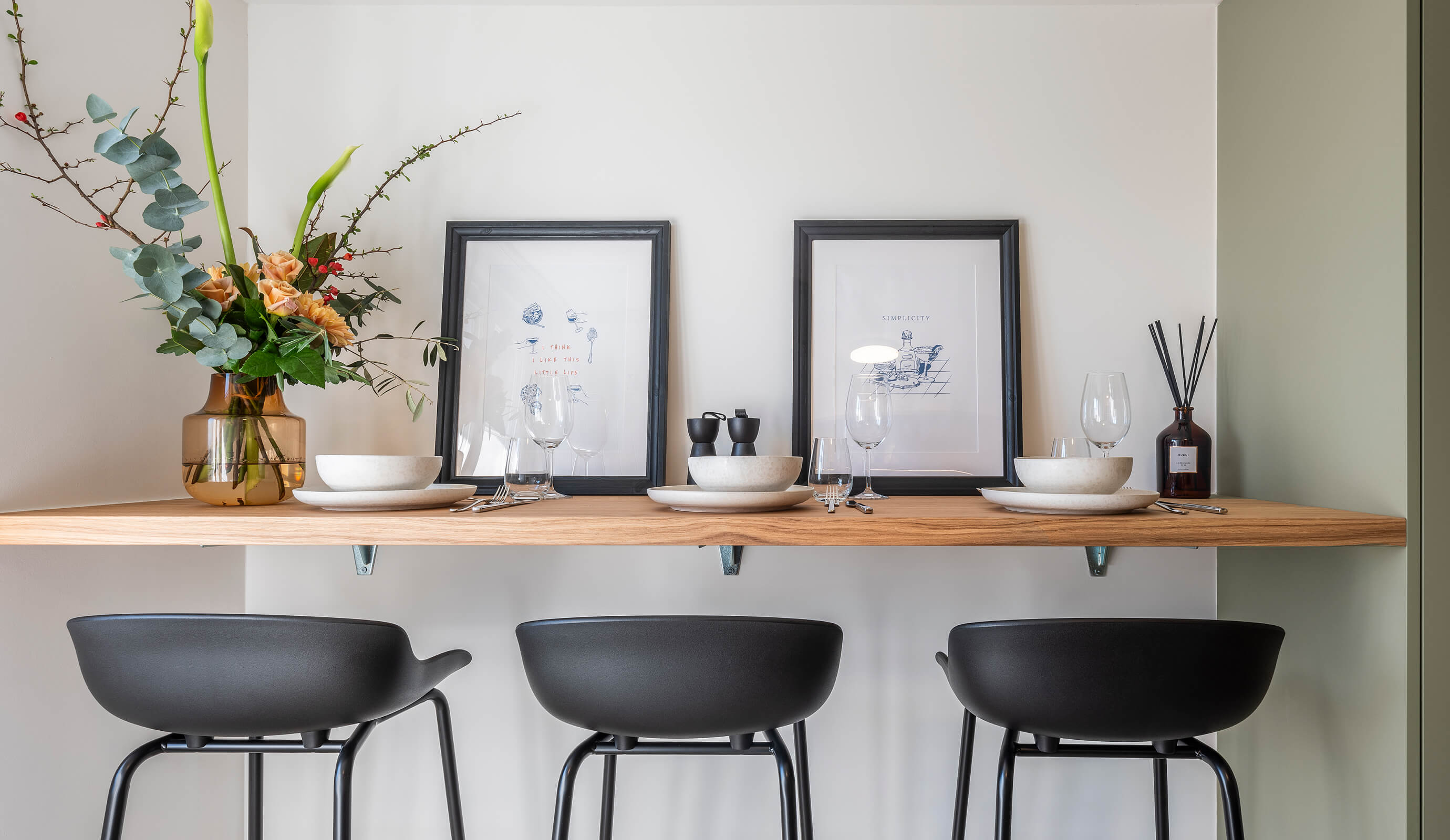 Residential Interiors – breakfast bar with stools, flowers and framed prints