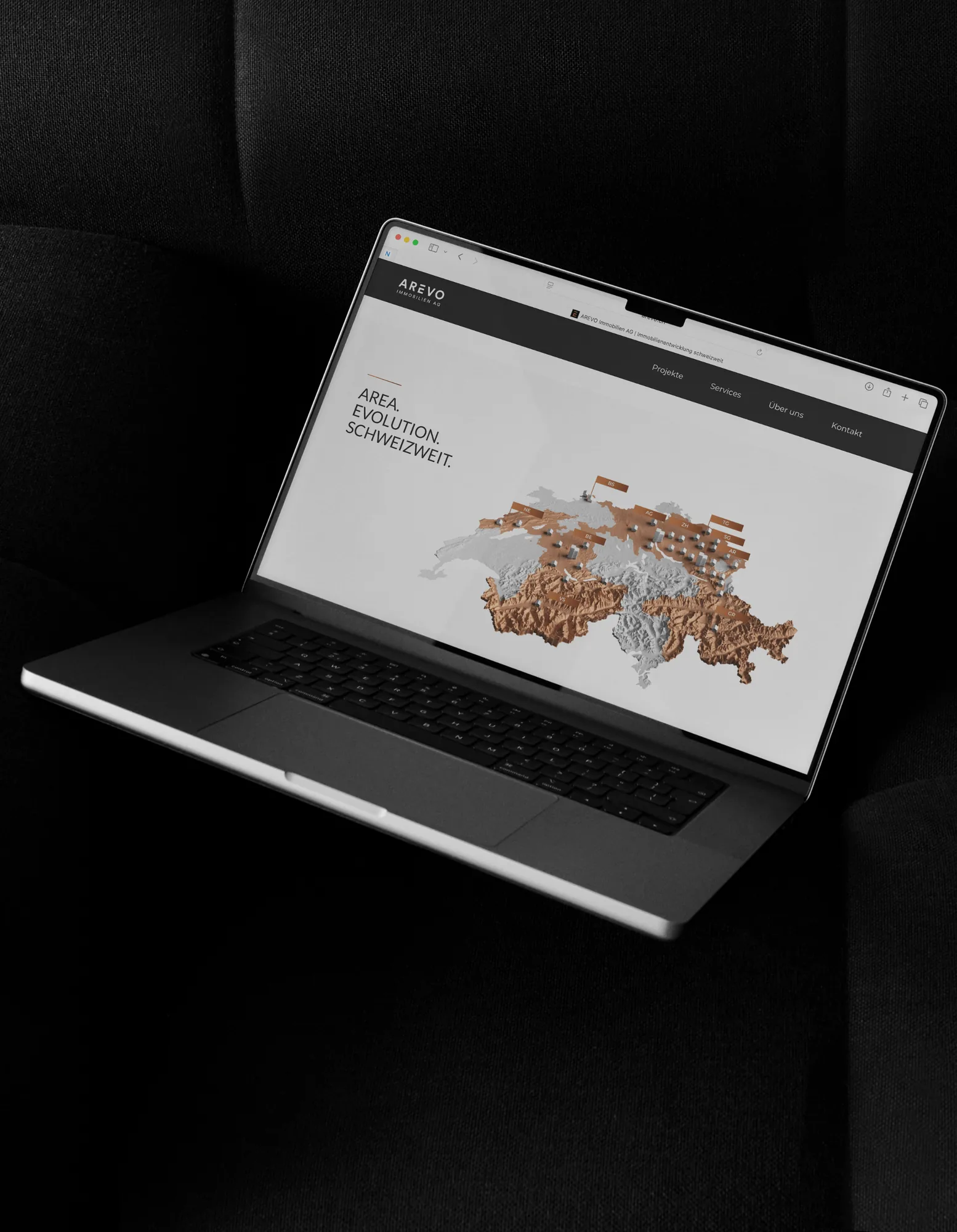 AREVO Immobilien AG – website on a laptop showing a relief map of Switzerland